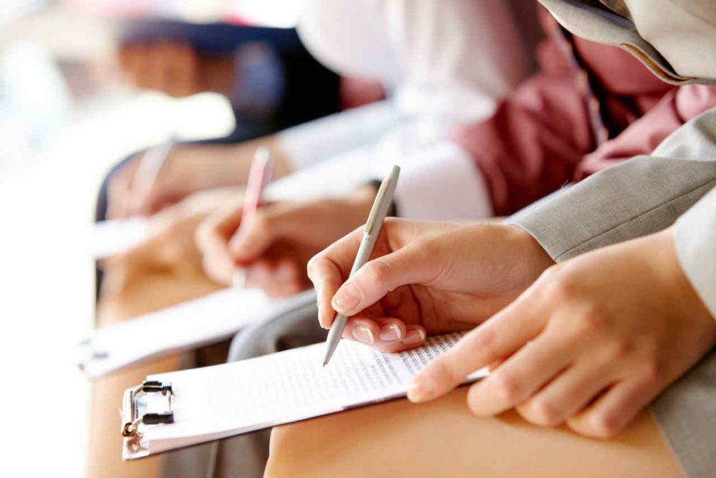 Business education Businesspeople hands over papers making notes at seminar